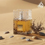 Refect Beauty Lattafa Khamrah Qahwa eau de parfum in a textured glass bottle set against a desert sand background.
