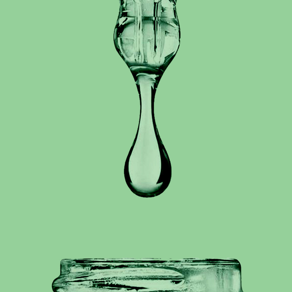 Refect Beauty Dermactive Acti-Clear Correcting Serum droplet falling from a glass pipette against a green background
