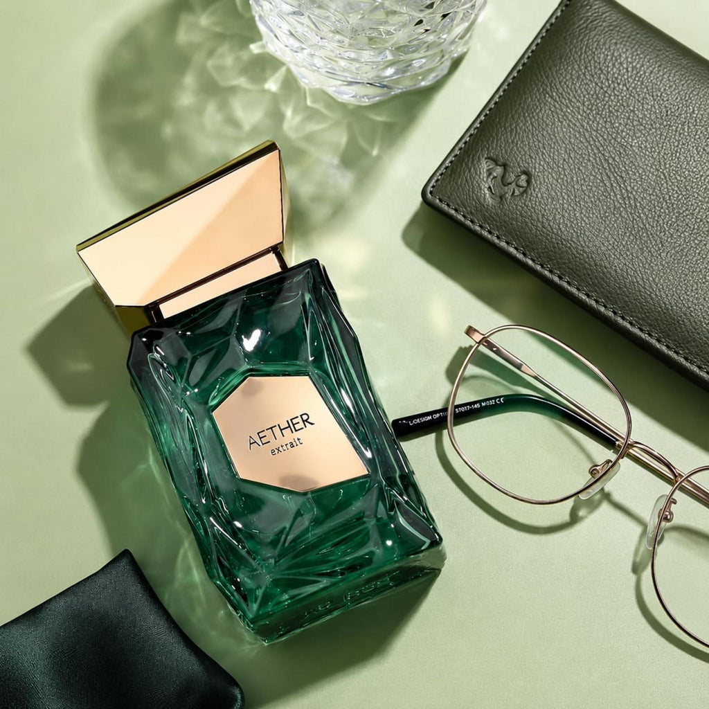 Refect Beauty French Avenue Aether extrait de parfum bottle with green faceted glass and gold cap on a desk