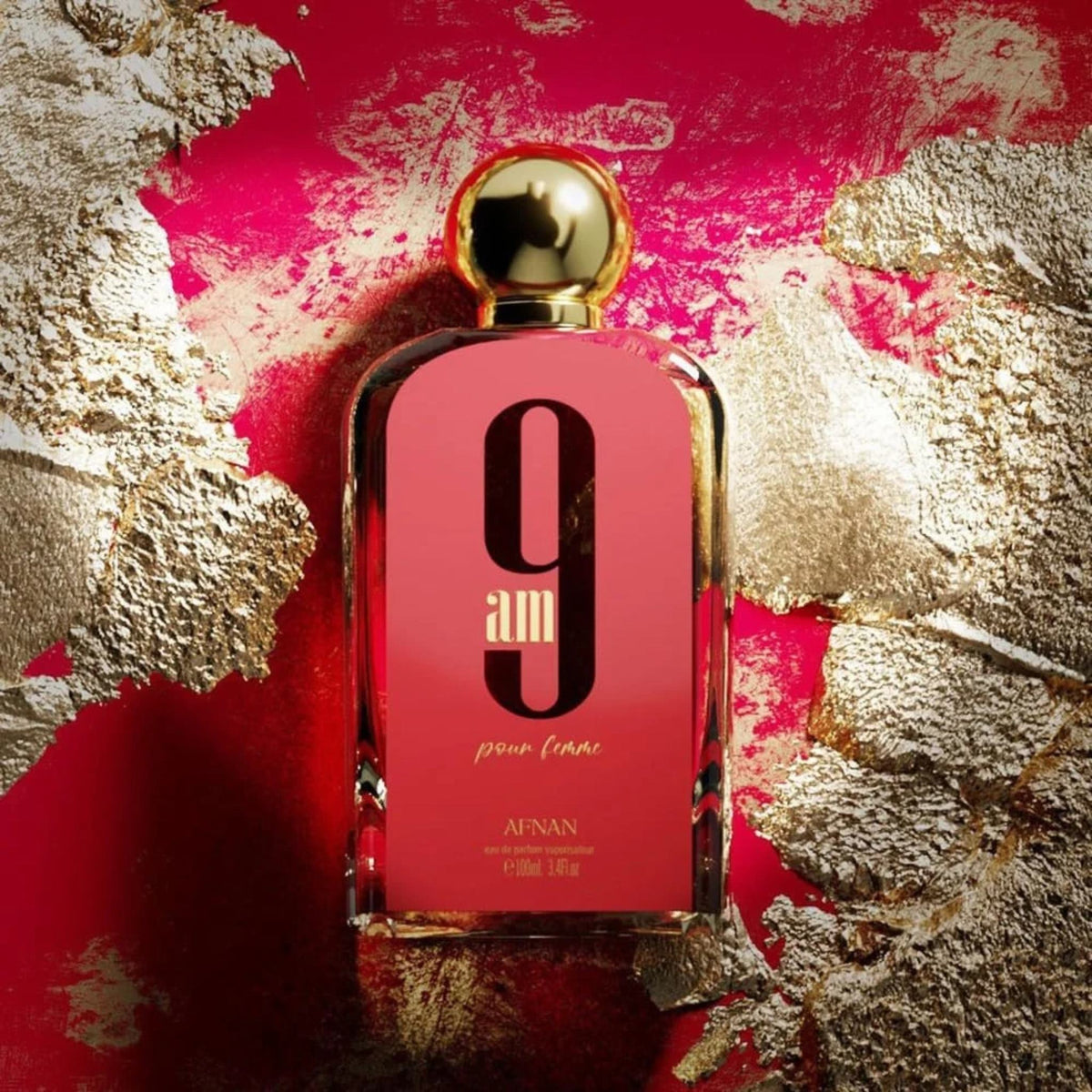 Refect Beauty Afnan 9AM Pink Femme eau de parfum bottle with gold cap on a vibrant pink and gold textured background