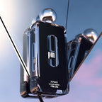 Refect Beauty Afnan 9PM Eau de Parfum bottle with a sleek black design, reflected in mirrors against a sunset sky.