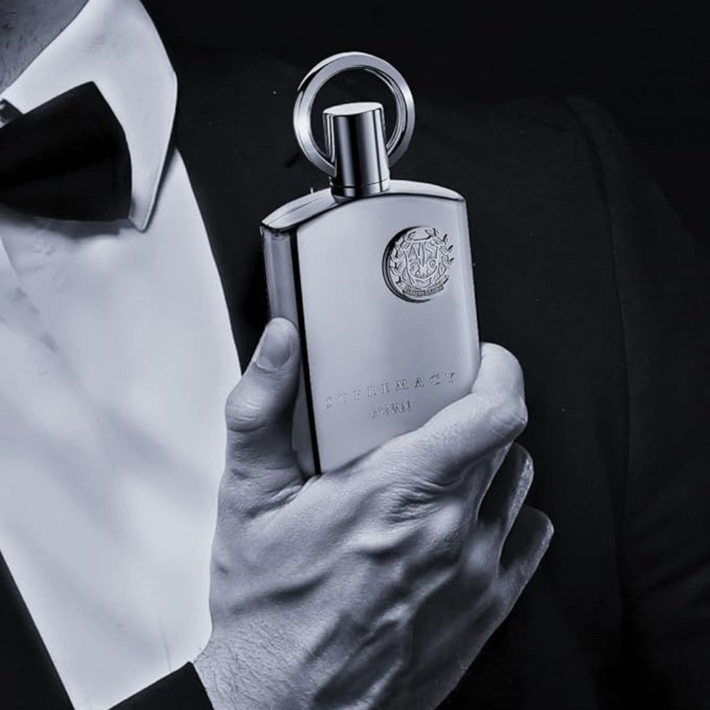 Refect Beauty Afnan Supremacy Silver perfume bottle held by a man in a black tuxedo and bowtie