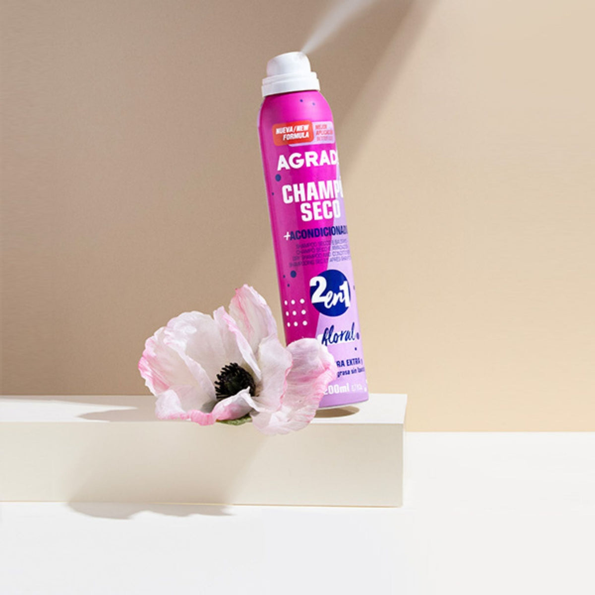 Refect Beauty Agrado 2-in-1 floral dry shampoo and conditioner spray can next to a white poppy flower