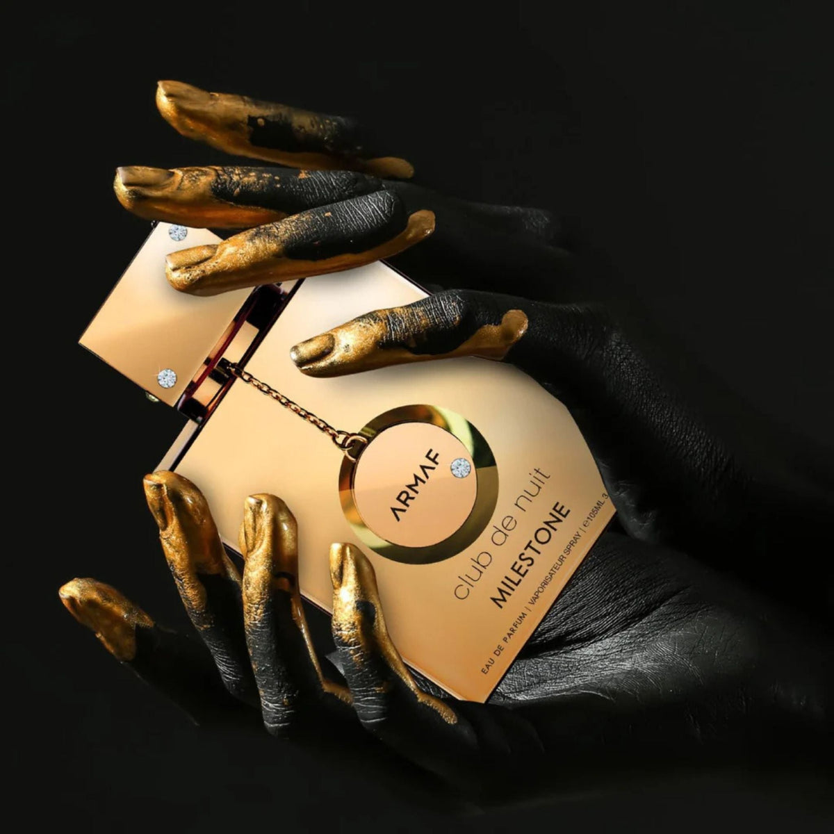 Refect Beauty Armaf Club de Nuit Milestone Eau de Parfum bottle held by hands painted in black and metallic gold