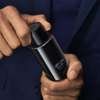 Refect Beauty Giorgio Armani Armani Code Parfum bottle held by a man in a navy blue suit jacket