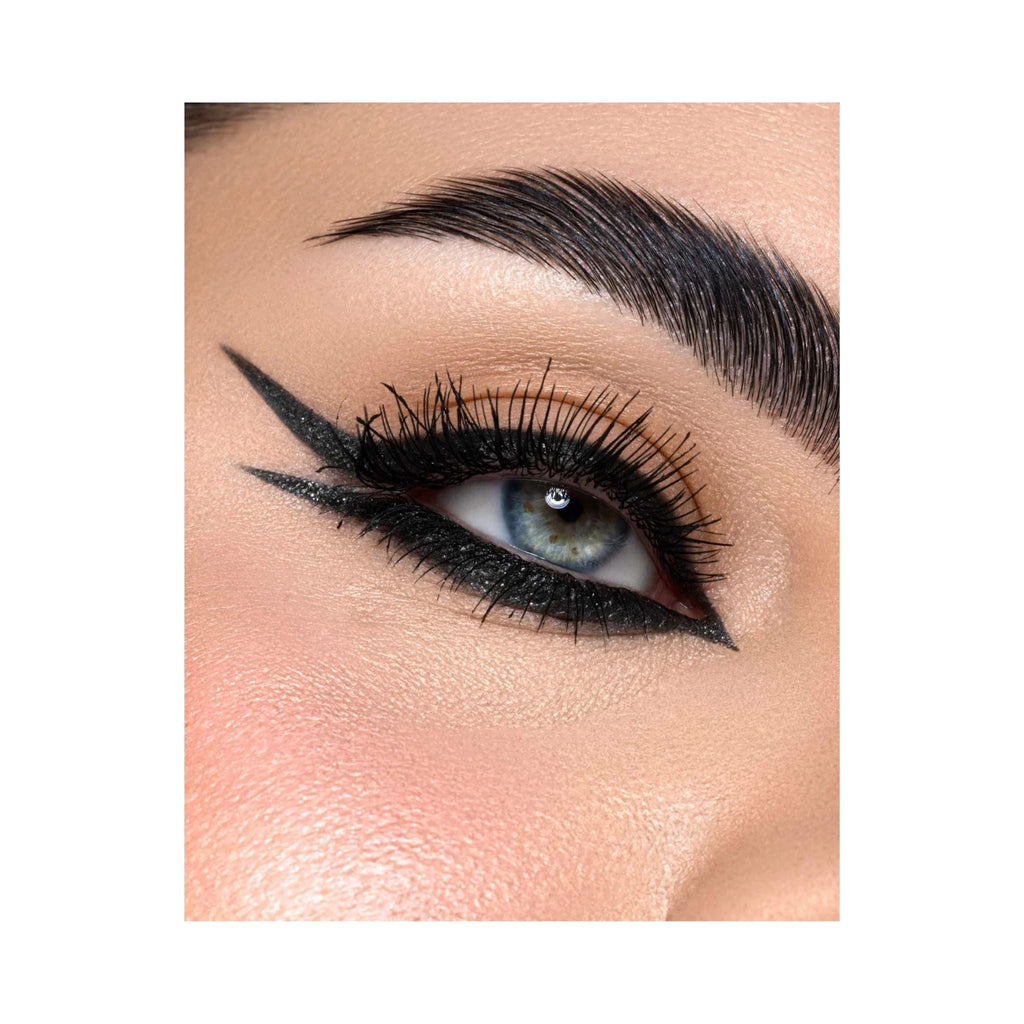 Refect Beauty Astra Black Glitter kajal eye pencil applied with a sharp winged eyeliner look on a blue-eyed model