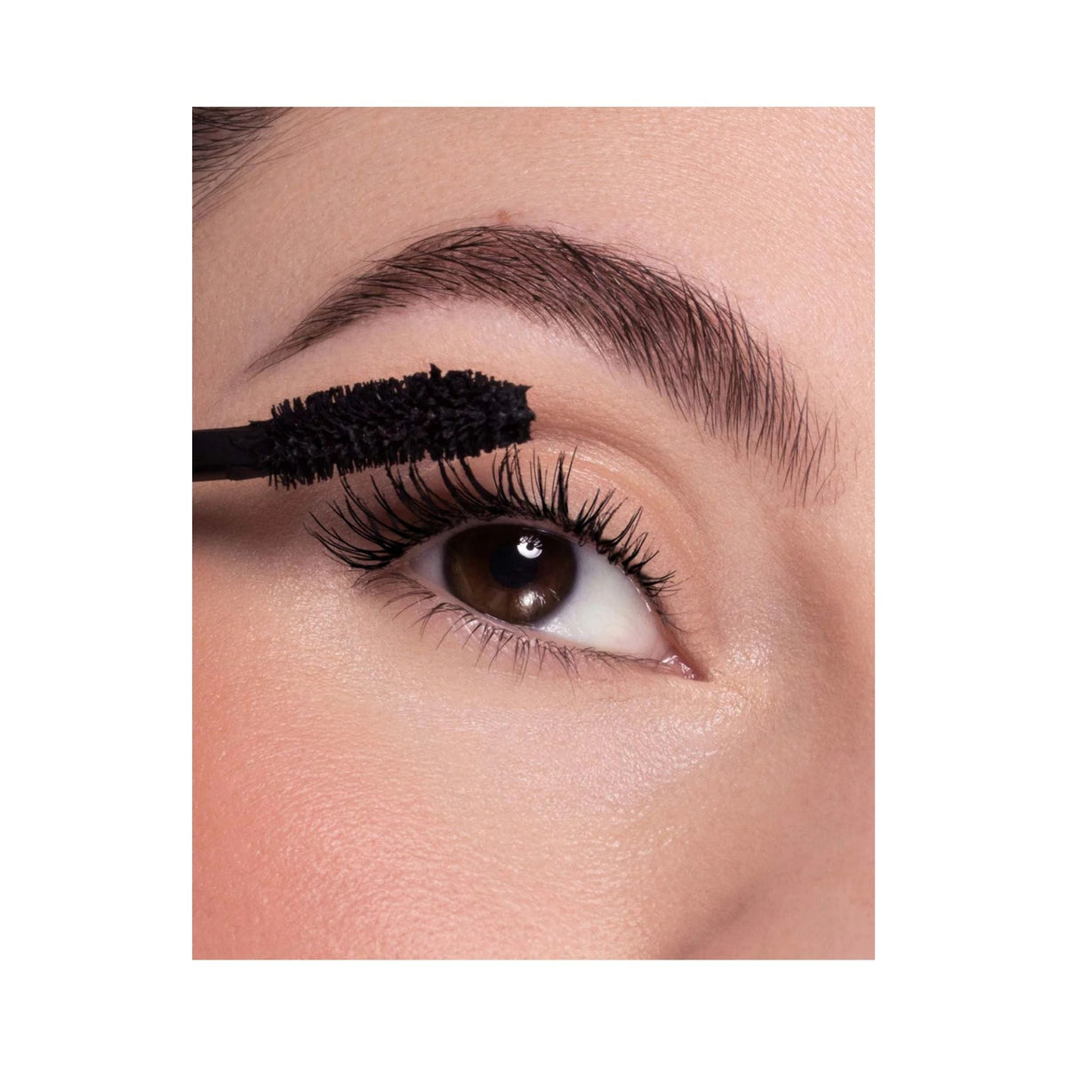Refect Beauty Astra Curling Volume mascara wand applying black mascara to long, lifted eyelashes for a voluminous look.