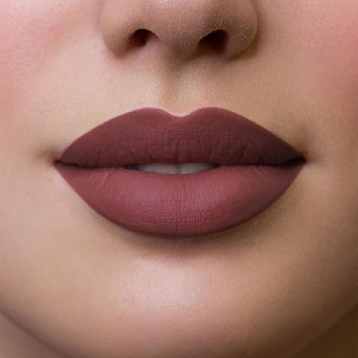 Refect Beauty Astra Hypnotize liquid lipstick in a matte mauve shade applied on lips for a bold, defined look