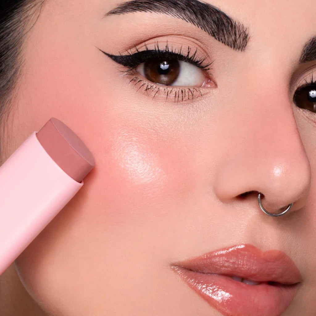 Refect Beauty Astra Identistick blush stick being applied to a model's cheek for a natural cream-to-powder finish