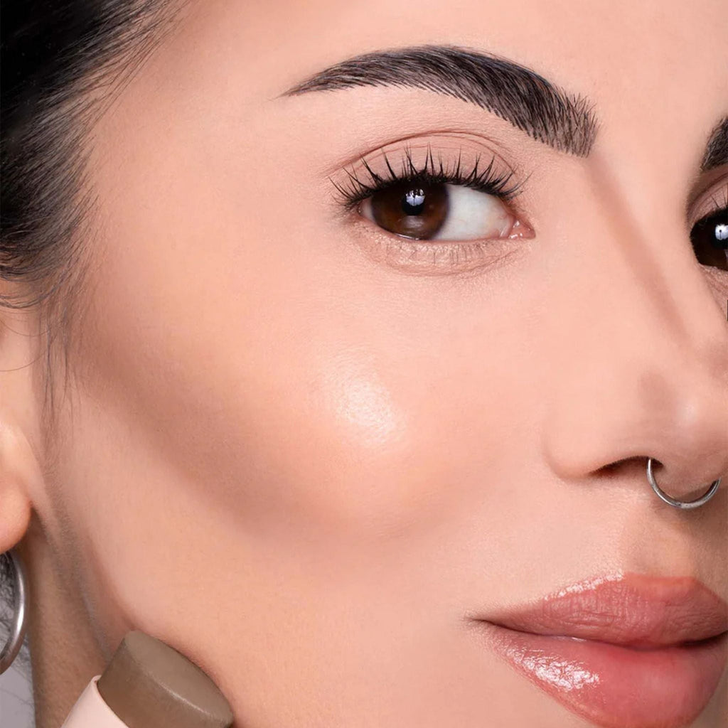 Refect Beauty Astra Identistick contour stick being applied to a model's cheekbone for a sculpted makeup look