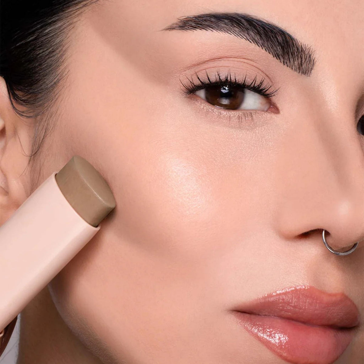 Refect Beauty Astra Identistick contour stick being applied to a model's cheekbone for a sculpted makeup look