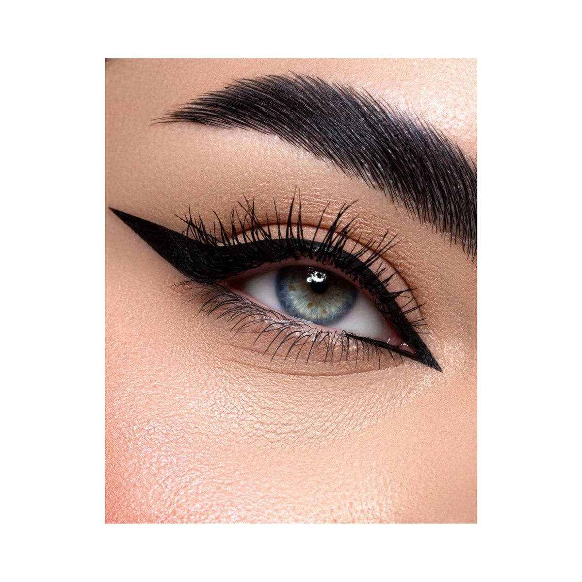 Refect Beauty Astra Ink Liner applied as a sharp black winged eyeliner on a blue-eyed model with groomed eyebrows.