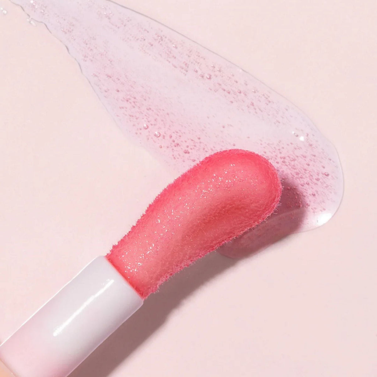 Refect Beauty Astra Pure Beauty Juicy Lip Oil applicator with a soft pink glossy texture on a light background