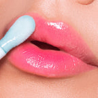 Refect Beauty Astra Pure Beauty Juicy Lip Oil in a glossy pink shade being applied to lips with a soft applicator.