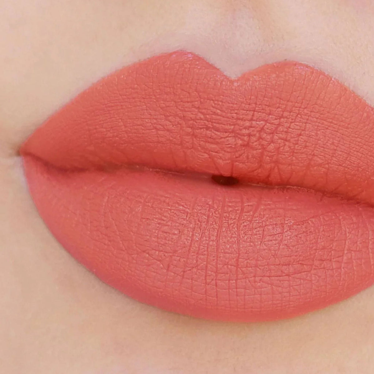 Refect Beauty Astra Jumbo Lipstick in a vibrant coral shade applied to lips for a smooth, matte finish.