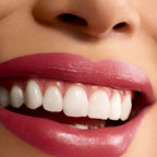 Refect Beauty Astra Lip Creamynal lipstick in a vibrant, luminous berry shade applied on smiling lips.