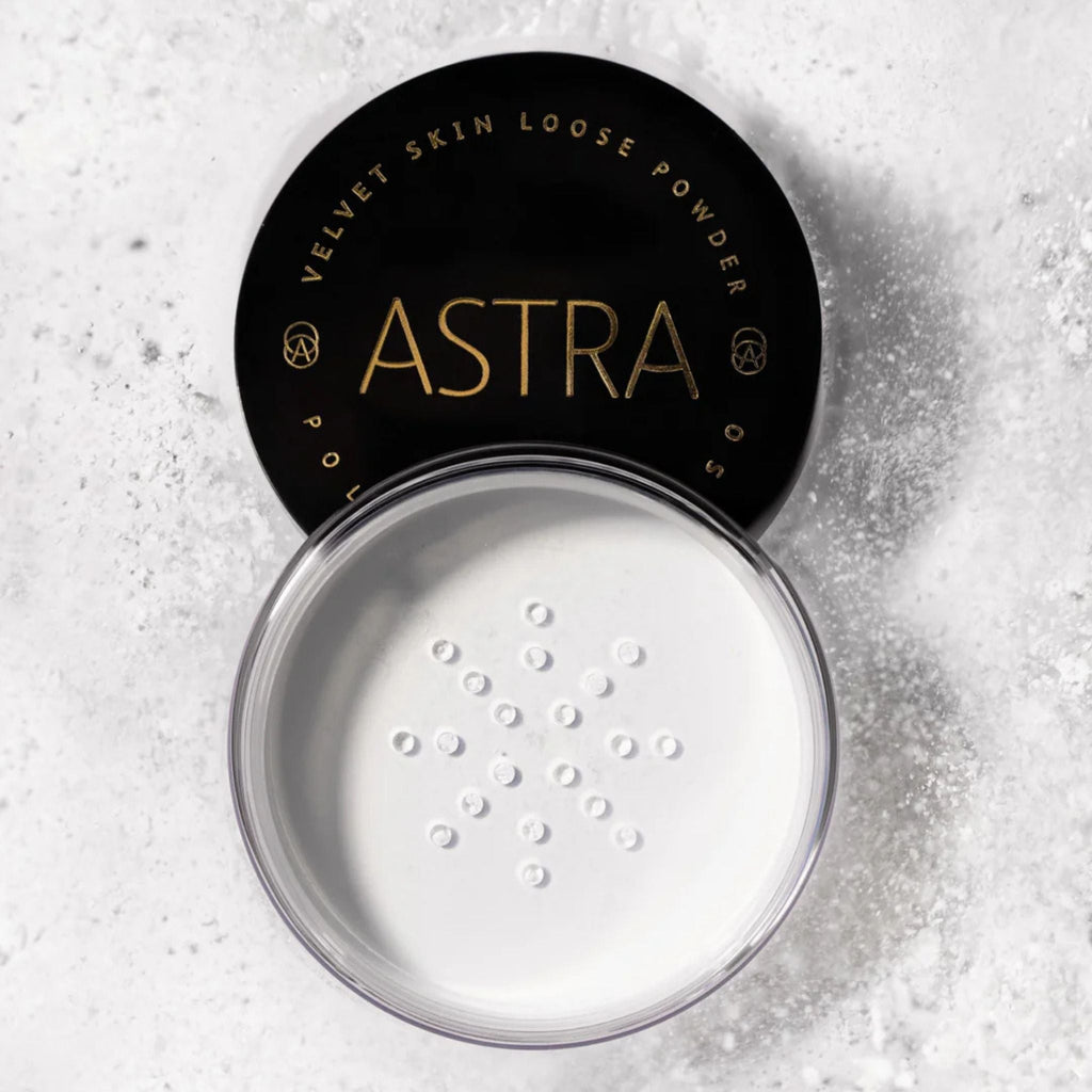 Refect Beauty Astra Velvet Skin loose translucent face powder in an open jar with a black lid on a textured surface