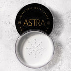 Refect Beauty Astra Velvet Skin loose translucent face powder in an open jar with a black lid on a textured surface