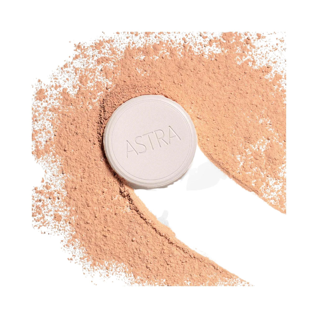 Refect Beauty Astra Natural Skin Powder compact surrounded by a swirl of loose beige face powder on a white background