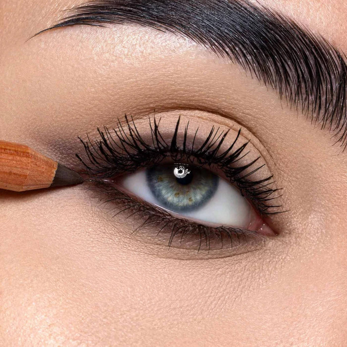 Refect Beauty Astra Pure Beauty Kajal eye pencil applying dark liner to the upper lash line of a blue eye
