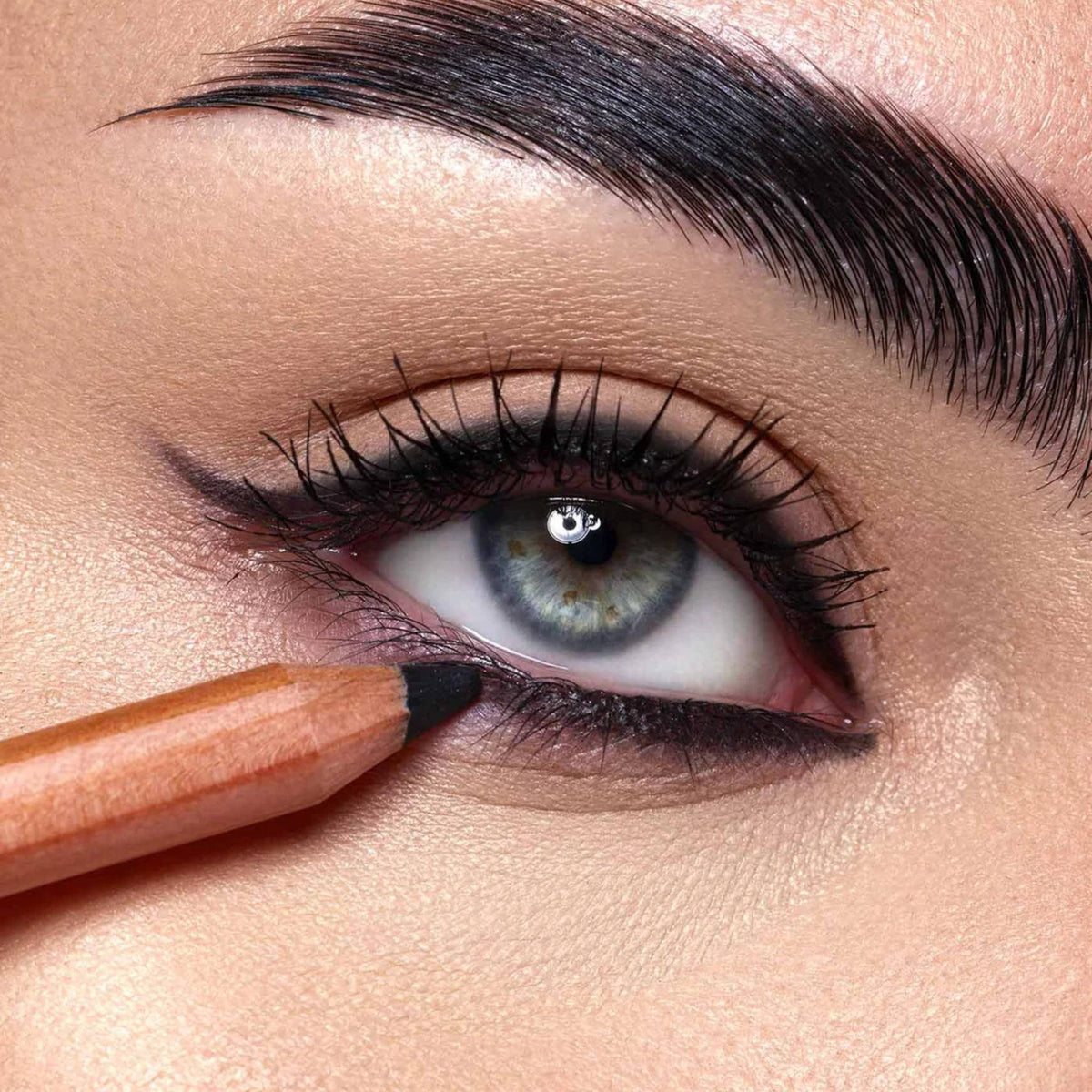 Refect Beauty Astra Pure Beauty black kajal eye pencil being applied to the lower lash line of a blue-eyed model