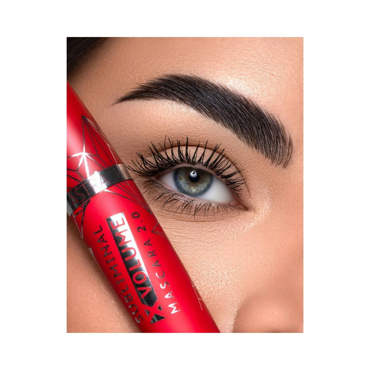 Refect Beauty Astra Subliminal X Volume 2.0 mascara tube held next to an eye with long, defined, extra-black lashes.