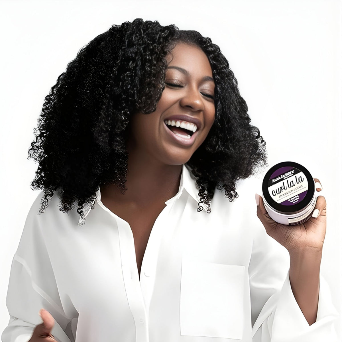 Refect Beauty model smiling while holding a jar of Aunt Jackie's Curl la la defining curl custard for natural hair