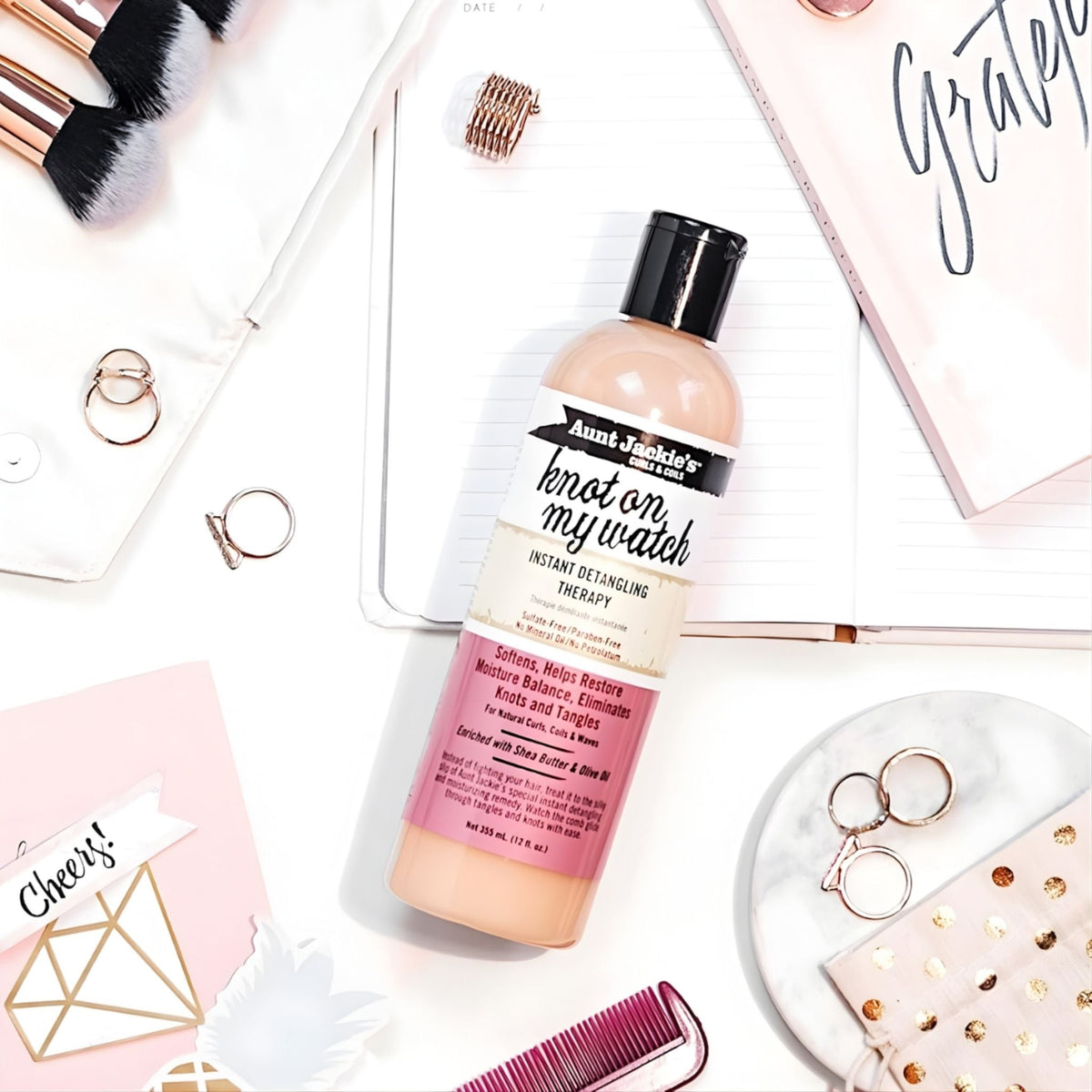Refect Beauty Aunt Jackie's Knot On My Watch detangling therapy bottle on a desk with makeup brushes and stationery