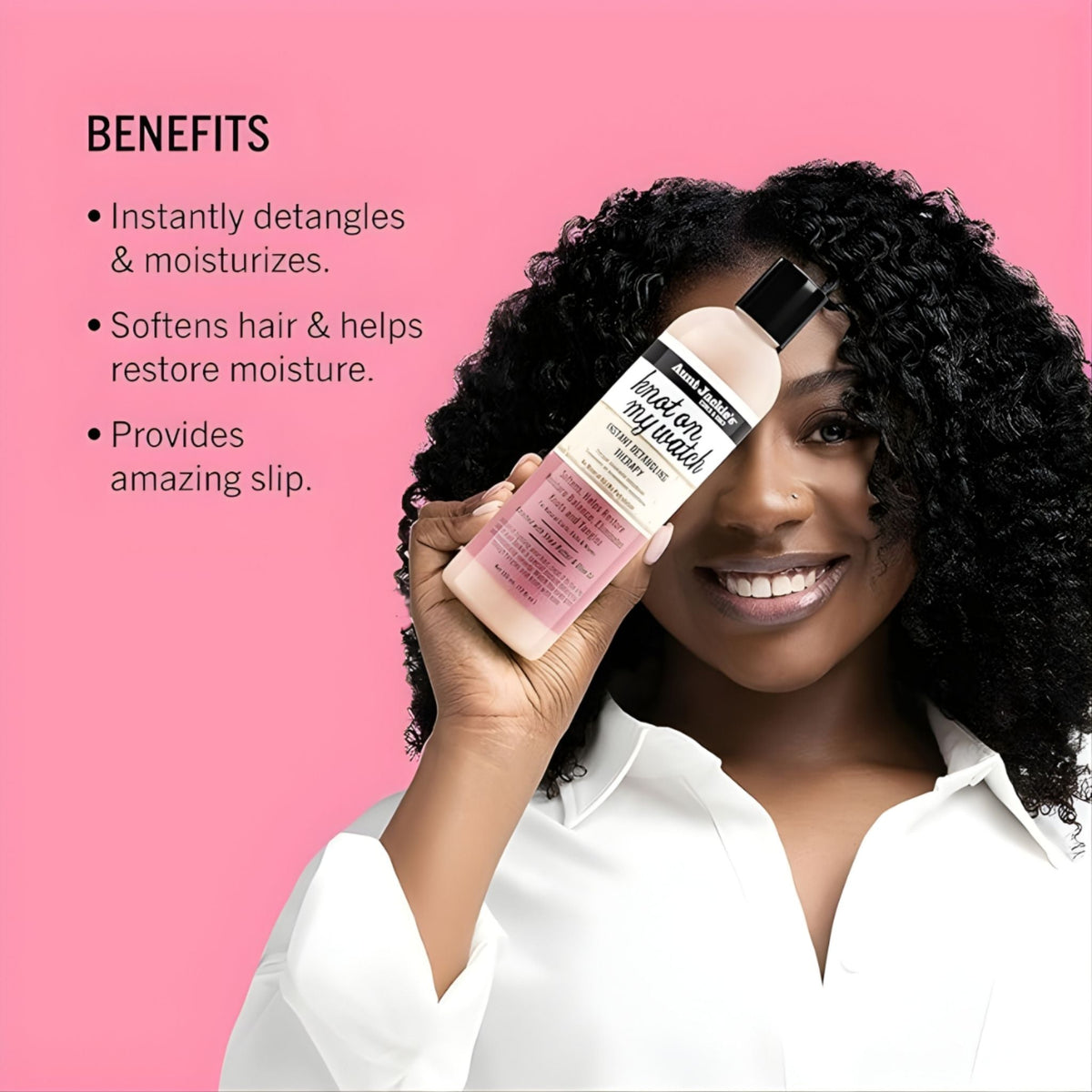 Refect Beauty model holding Aunt Jackie's Knot On My Watch detangling therapy bottle against a pink background