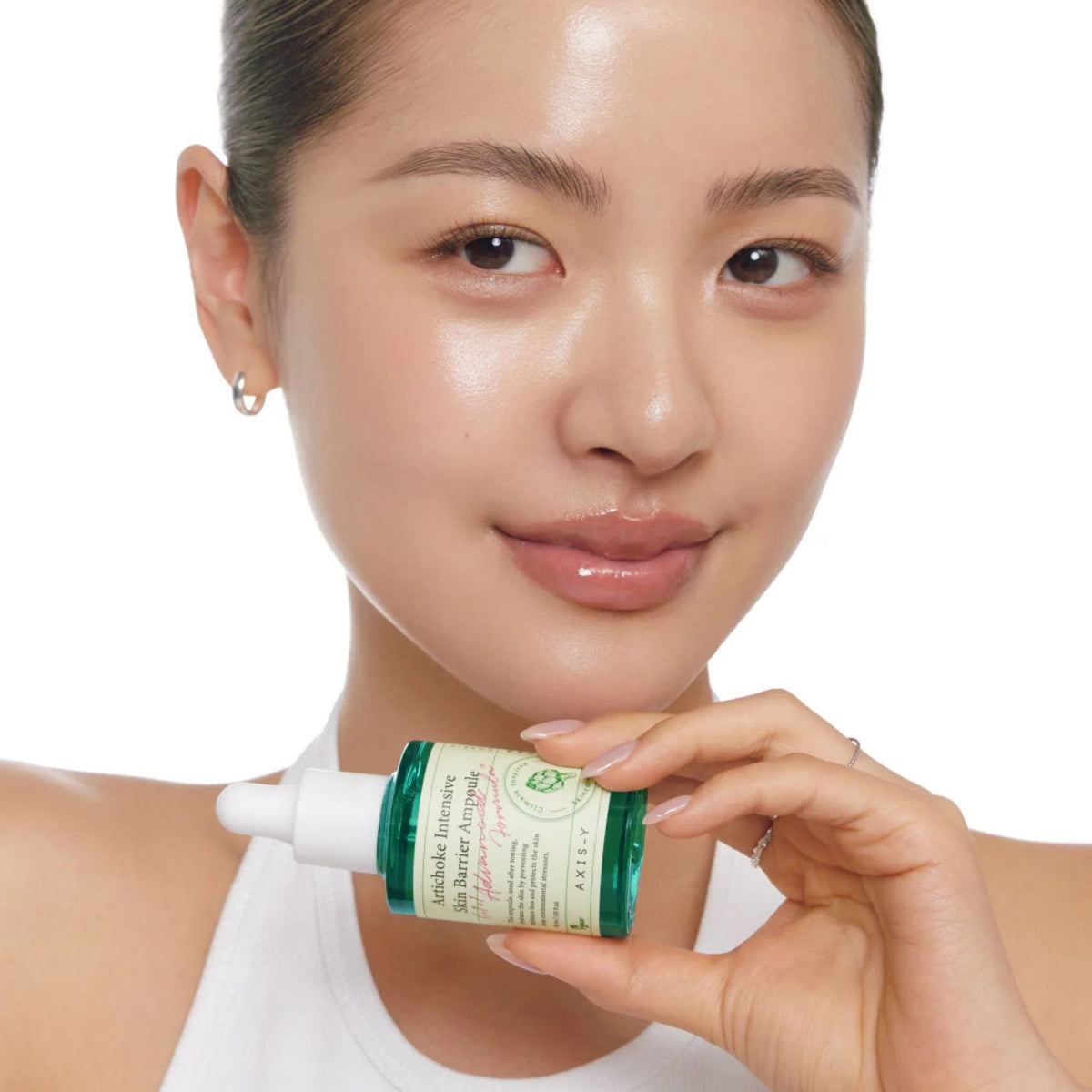 Refect Beauty model holding AXIS-Y Artichoke Intensive Skin Barrier Ampoule serum bottle against a white background