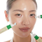 Refect Beauty AXIS-Y Vegan Collagen Eye Serum being applied to a model's under-eye area with a cooling roller tip.
