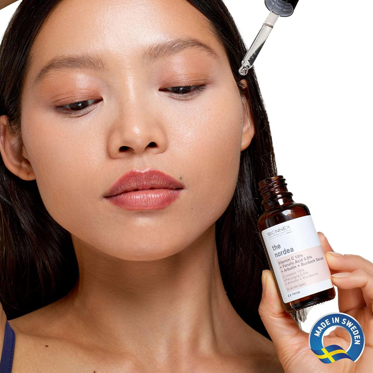 Refect Beauty model applying Bionnex THE NORDEA 15% Vitamin C brightening serum to her face with a dropper