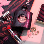 Refect Beauty Yves Saint Laurent Black Opium perfume bottle with glittery finish, red lipstick, and gold rings.