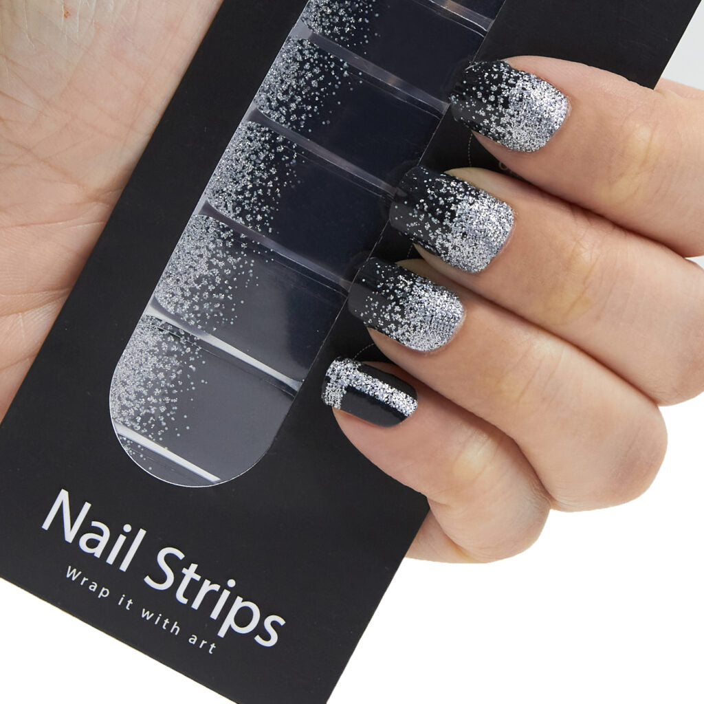 Refect Beauty Yolo Nail Strips featuring a black and silver glitter gradient design applied to a hand