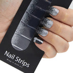 Refect Beauty Yolo Nail Strips featuring a black and silver glitter gradient design applied to a hand