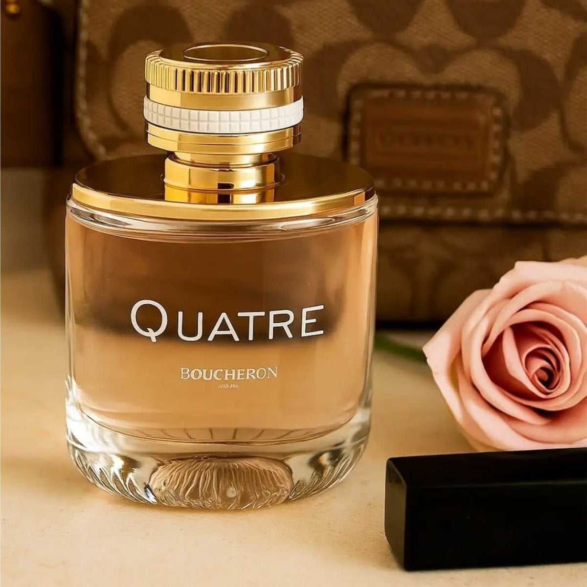 Refect Beauty Boucheron Quatre Pour Femme Eau de Parfum glass bottle with gold cap next to a pink rose