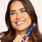 Refect Beauty model wearing vibrant blue mascara with matching eyeliner, holding a Bourjois Twist Up The Volume tube.