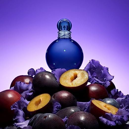 Refect Beauty Britney Spears Midnight Fantasy perfume bottle surrounded by fresh plums and purple flowers