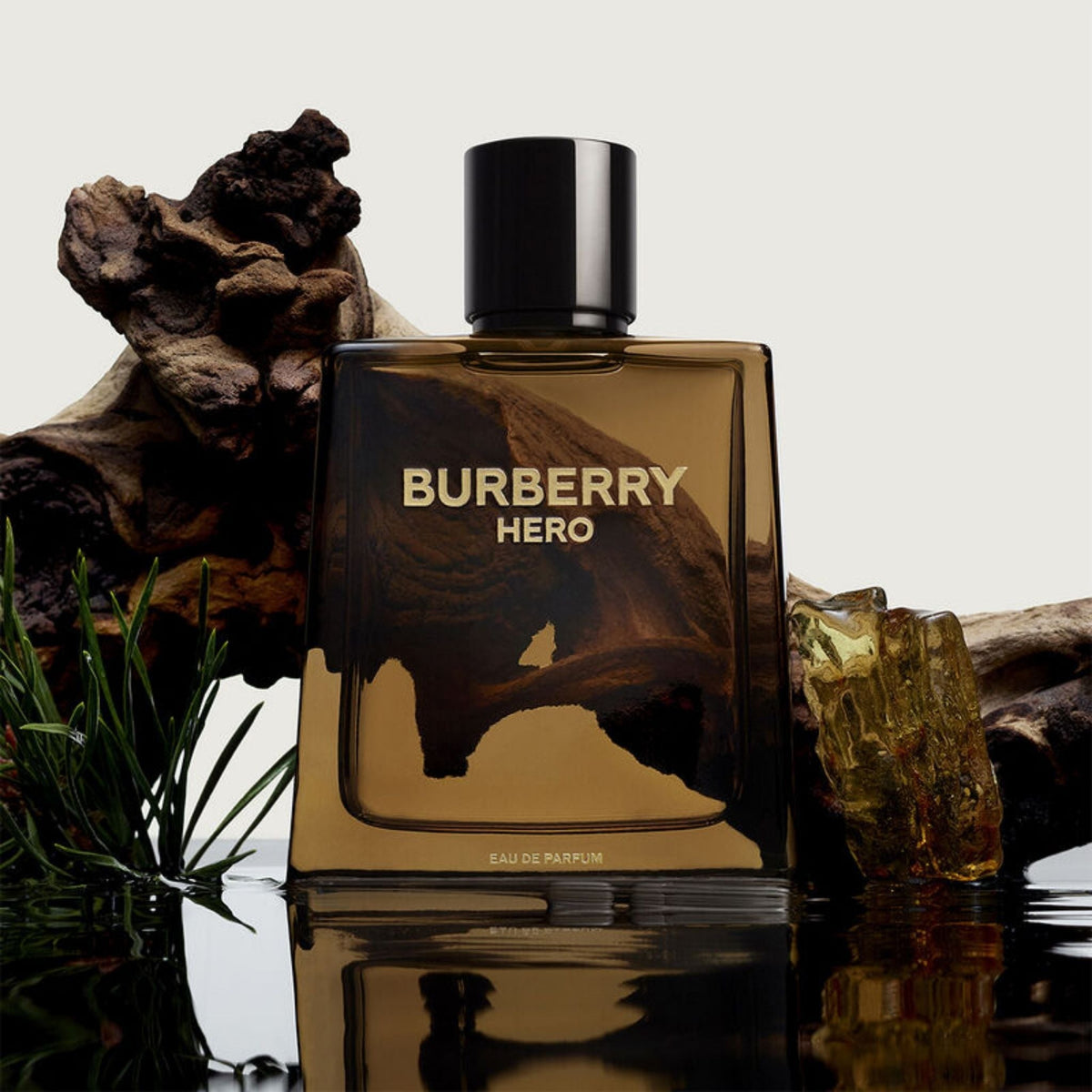 Refect Beauty Burberry Hero Eau de Parfum bottle with woody, aromatic notes displayed against driftwood and pine.