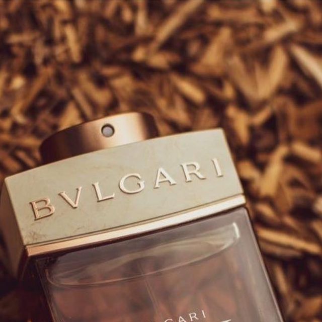 Refect Beauty Bvlgari Man Terrae Essence Eau de Parfum bottle with metallic cap resting on a bed of wood chips