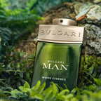 Refect Beauty Bvlgari Man Wood Essence eau de parfum bottle nestled in lush green ferns and textured tree bark