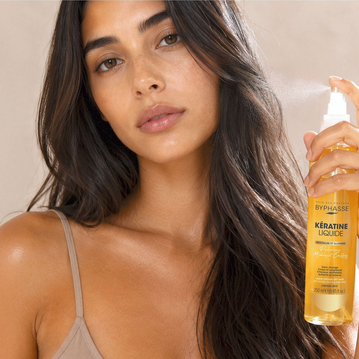 Refect Beauty model applying Byphasse Liquid Keratin spray to her long dark hair for shine and frizz control
