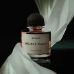 Refect Beauty Byredo Mojave Ghost Absolu de Parfum bottle with a black cap draped in elegant white fabric.
