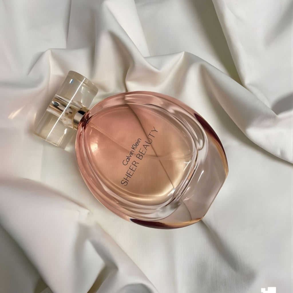 Refect Beauty Calvin Klein Sheer Beauty Eau de Toilette in a soft pink oval glass bottle on white draped fabric