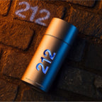 Refect Beauty Carolina Herrera 212 Men NYC Eau de Toilette bottle on a textured stone surface with urban lighting