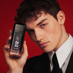 Refect Beauty model holding a black Carolina Herrera 212 VIP Black fragrance bottle against a bold red background.