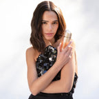 Refect Beauty model holding a bottle of Carolina Herrera 212 VIP Rosé Eau de Parfum in a glamorous sequined dress