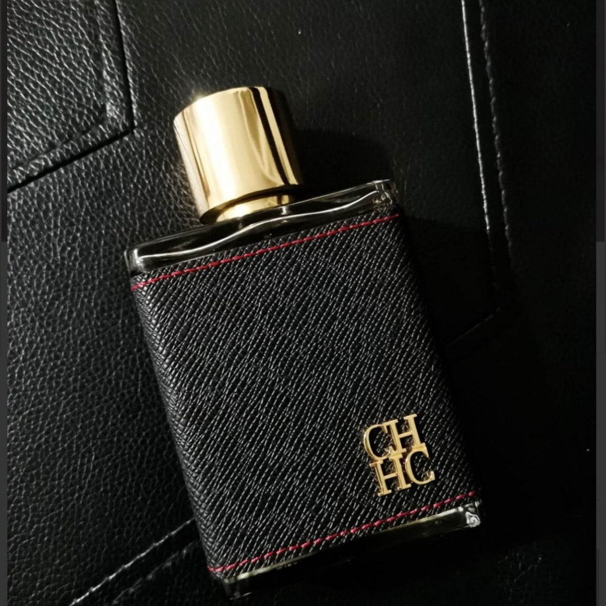 Refect Beauty Carolina Herrera CH Men Eau de Toilette in a black leather-wrapped bottle with a gold cap.
