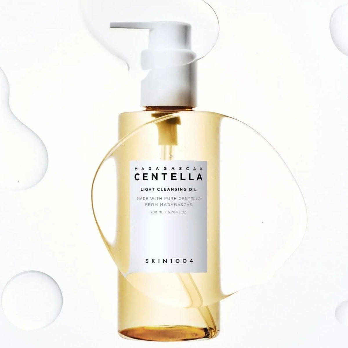 Refect Beauty Centella Light Cleansing Oil in a clear bottle with a pump dispenser, surrounded by water droplets.