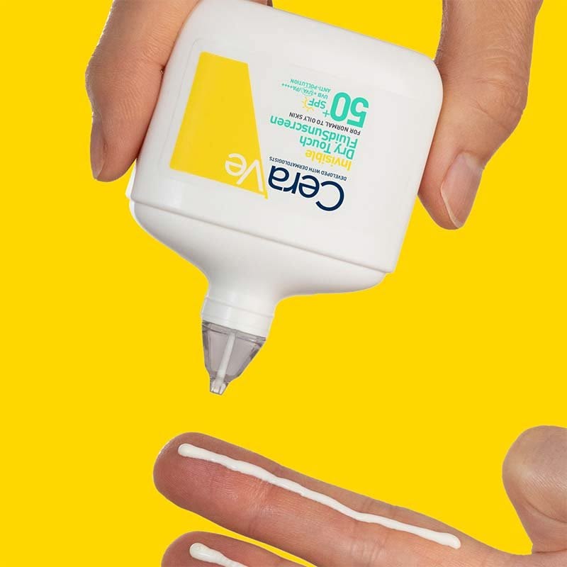 Refect Beauty CeraVe Invisible Dry Touch Fluid Sunscreen SPF 50+ being applied to a finger against a yellow background
